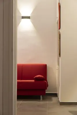 a red couch in a room with a light at Casa Vacanze Fausta in Rome