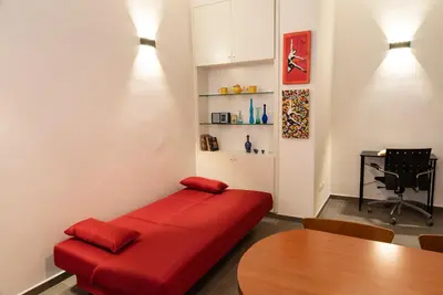 a red couch in a room with a table at Casa Vacanze Fausta in Rome