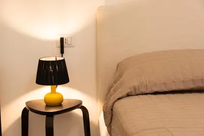 a lamp sitting on a table next to a bed at Casa Vacanze Fausta in Rome