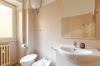 a white bathroom with a sink and a toilet at Casa d' artista Margot in Rome