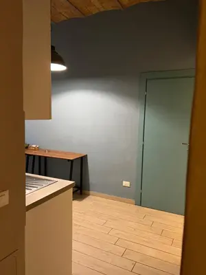 a kitchen with a blue wall and a wooden floor at GA Holidays Home2 in Rome