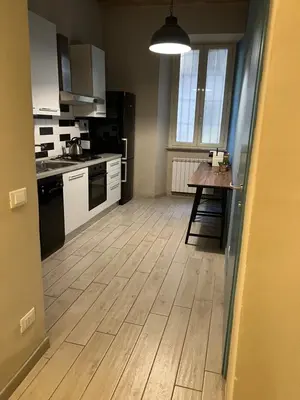 a kitchen with a wooden floor and a table at GA Holidays Home2 in Rome
