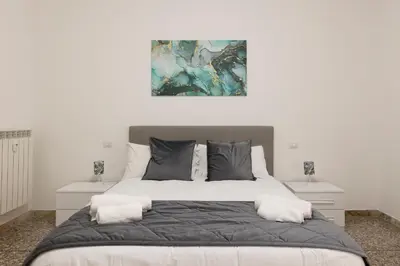 a bedroom with a large bed with a painting on the wall at Central Modern Apartment - Trastevere & Vaticano in Rome