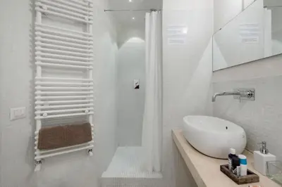 a white bathroom with a sink and a shower at Charming apartment near Villa Borghese in Rome