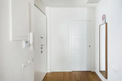 a white hallway with a door and a mirror at Charming apartment near Villa Borghese in Rome