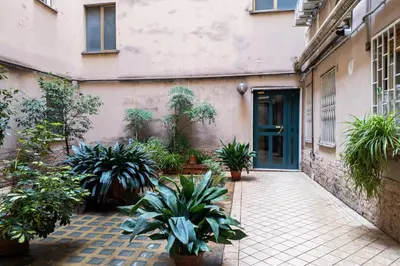 a courtyard with potted plants in front of a building at Porta Furba Apartment in Rome