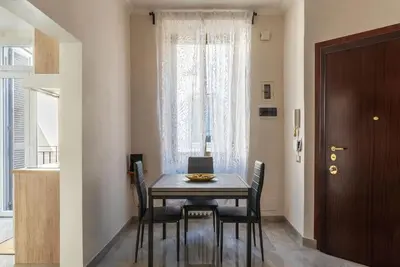 a dining room with a table and chairs and a window at GuestHost - Sweety Apartment near MM Ottaviano in Rome
