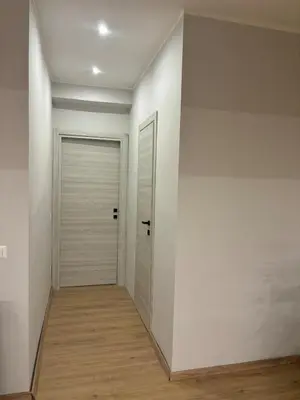 a hallway with white walls and a door at Suite dell'Arte - Metro linea A in Rome