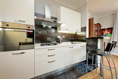 a kitchen with white cabinets and a stove top oven at Domus Monamì Dreams & Terrace in Trastevere in Rome