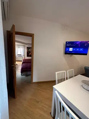 a living room with a table and a tv on the wall at Bella Trastevere in Rome