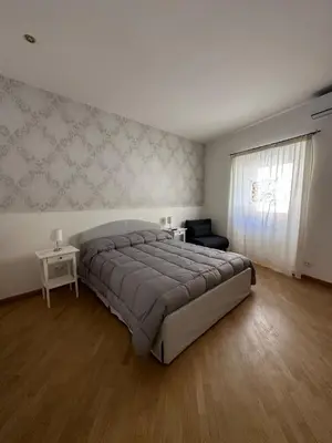 a bedroom with a bed and a chair and a window at Bella Trastevere in Rome