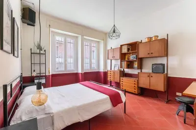 a bedroom with a bed and a dresser and window at Maroon Flat Colosseo, 800 mt from Amphitheater in Rome