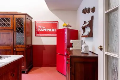 a red refrigerator in a kitchen next to a counter at Maroon Flat Colosseo, 800 mt from Amphitheater in Rome