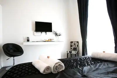 a bedroom with a bed with towels and a television at Rome Key Luxury House in Rome