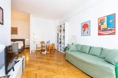 a living room with a green couch and a table at Pop Studio Trastevere in Rome