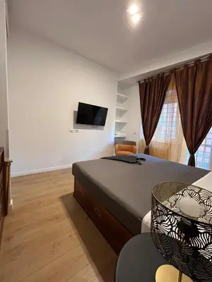 a bedroom with a bed and a flat screen tv at Roman Interlude in Rome