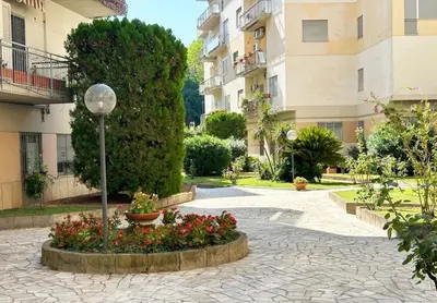 a courtyard of a building with flowers and a street light at Roman Interlude in Rome