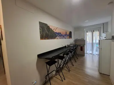 a kitchen with a bar with chairs and a refrigerator at Luma rooms in Rome
