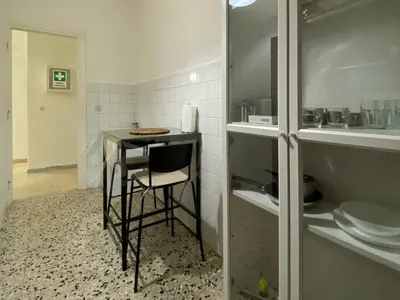a small kitchen with a table and a stool at Tiburtina2000 in Rome