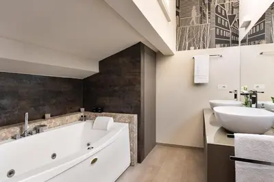 a bathroom with a large tub and a sink at Idyllia - Borgognona luxury home in Rome