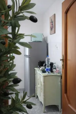 a kitchen with a table with a refrigerator in it at Mari & Lucio Bright Rome Apartment Sleeps 4 near Metro Basilica San Paolo- 4 Stops to Colosseum- Wi-Fi AC in Rome