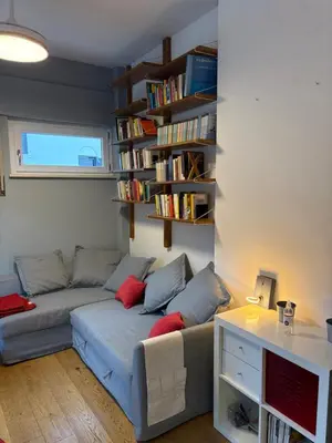 a living room with a couch and book shelves at Urban Escape a Piazza Caprera in Rome