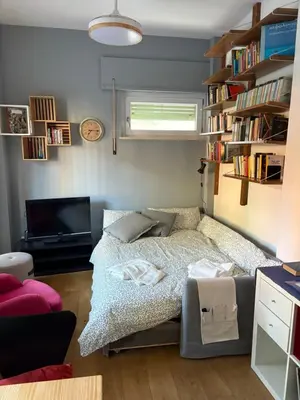 a bedroom with a bed and a tv and books at Urban Escape a Piazza Caprera in Rome