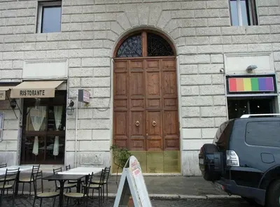 a building with a wooden door and tables and chairs at Colosseo28 three private rooms in Rome