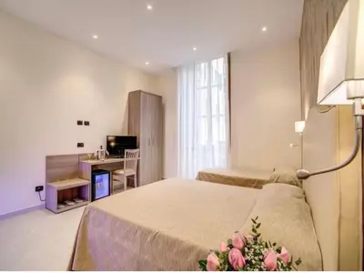 a bedroom with two beds and a desk and a television at Colosseo28 three private rooms in Rome