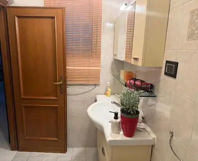 a bathroom with a sink and a toilet and a mirror at Vatican House in Rome