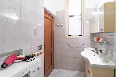 a bathroom with a sink and a red vacuum at Vatican House in Rome