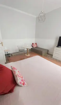 a bedroom with a white bed with red pillows at Tra i Musei Vaticani House in Rome