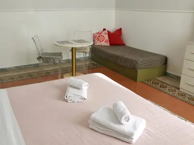 a room with a bed and a table with towels at Tra i Musei Vaticani House in Rome
