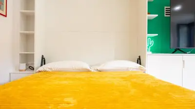 a bedroom with a bed with two pillows and a television at Villa Paolina by Rentbeat in Rome