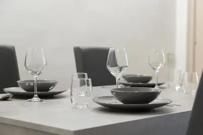 a table with wine glasses and plates on it at Roma - Parione House in Rome