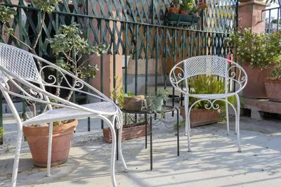 two chairs and a table in front of a fence at Governo Central Apartment in Rome