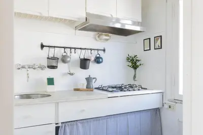 a white kitchen with a sink and a stove at Governo Central Apartment in Rome