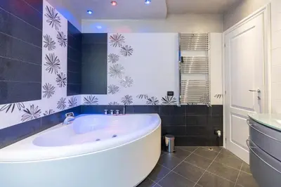 a bathroom with a white tub and blue tiles at Stella su San Pietro in Rome