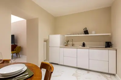 a kitchen with white cabinets and a wooden table at Casa Green by Hili in Rome