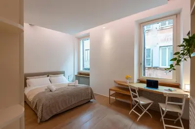 a bedroom with a bed and a desk with a computer at Coronari Navona luxury 1 bedroom 2 bathrooms in Rome