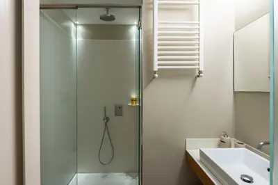 a shower with a glass door next to a sink at Coronari Navona luxury 1 bedroom 2 bathrooms in Rome