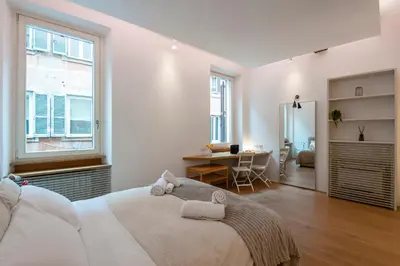 a white bedroom with a large bed and a desk at Coronari Navona luxury 1 bedroom 2 bathrooms in Rome