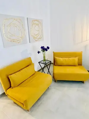 a yellow couch and a chair in a room at Palmira house in Rome
