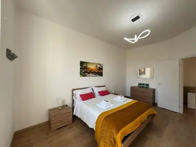a bedroom with a large bed with red pillows at Urban Retreat Steps from the Metro in Rome