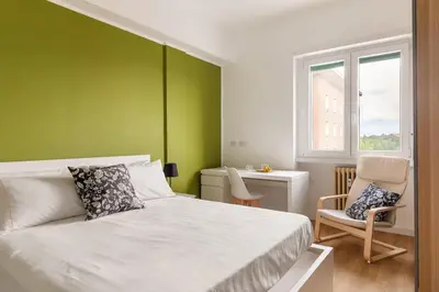a bedroom with a bed and a green wall at Design Apartment, near Tiburtina Station in Rome
