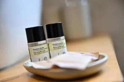 three bottles of moisturizers on a plate on a table at Cozy Studio Steps from Metro station in Rome