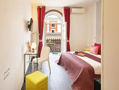 a bedroom with a bed and a window with red curtains at Relais Quattro Fontane in Rome