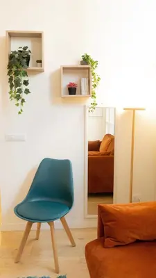a blue chair in a room with a bedroom at Aria Charme in Rome