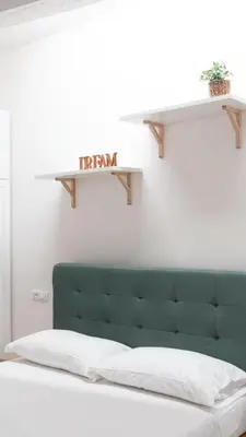 a bed with a green headboard in a room at Aria Charme in Rome