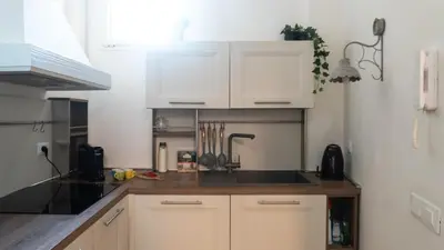 a kitchen with white cabinets and a counter top at Aria Charme in Rome